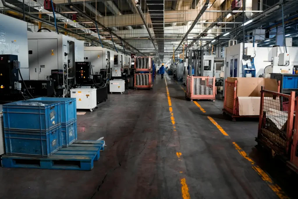 Lantai pabrik industri manufaktur dengan conveyor belt dan workstation terstruktur untuk proses produksi